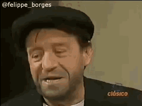 a man wearing a hat and a suit is smiling .
