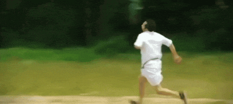 a man in a white shirt and white shorts is running on a field .