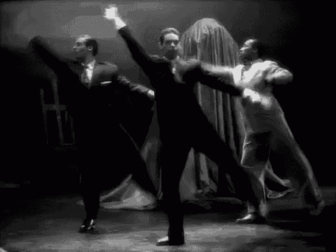 a group of men are dancing on a stage in front of a ghost .