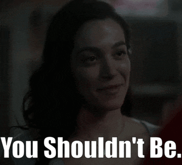 a woman is smiling with the words " you shouldn 't be " behind her