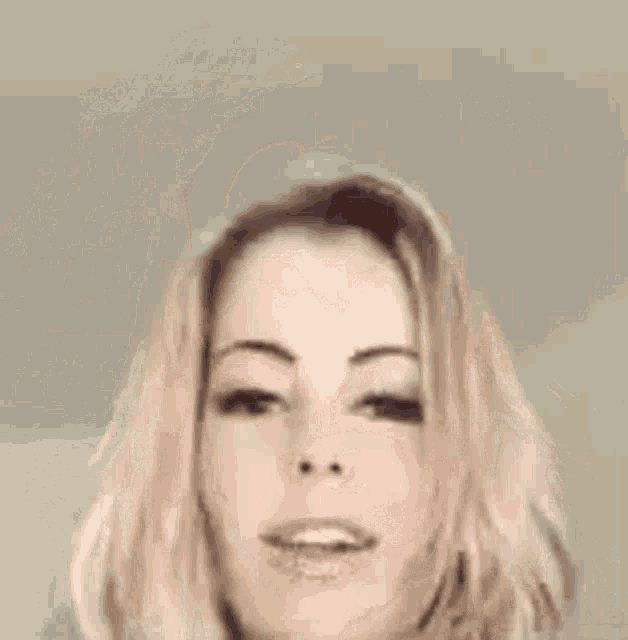 a close up of a woman 's face with her eyes closed and a smile on her face