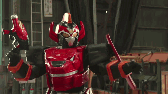 a red and white robot is standing in a warehouse with a sign that says ' no smoking ' on it