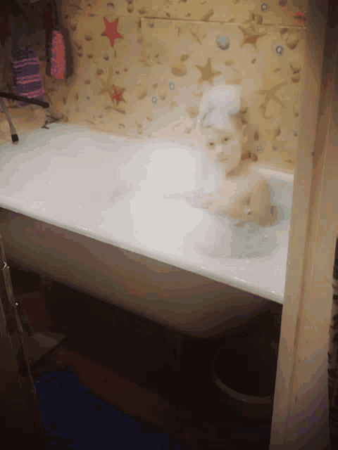 a little girl is taking a bath in a bathtub