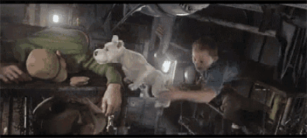 a man and a boy are laying on a table with a white dog .