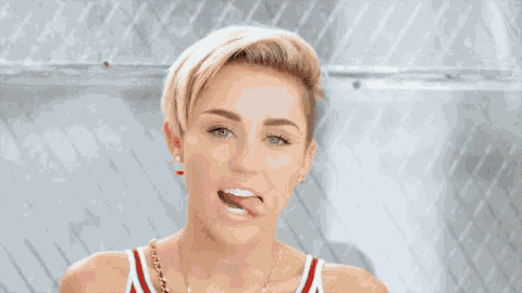 a woman with a shaved head is making a funny face with her tongue sticking out .
