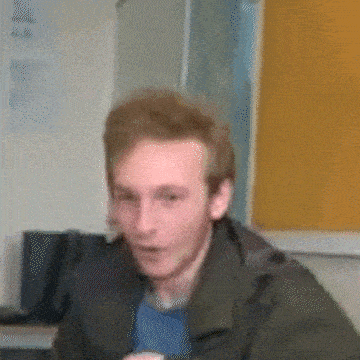 a blurry picture of a man in a green jacket and blue shirt