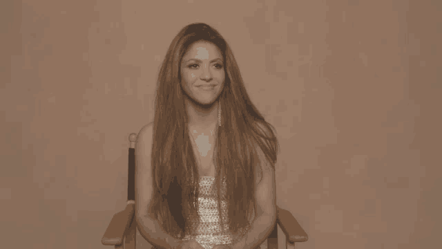 a woman with long hair sits in a chair