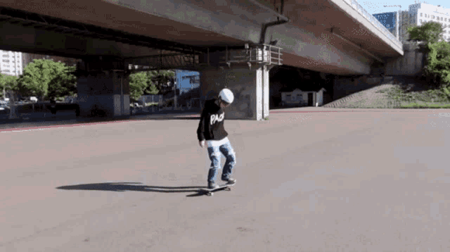 a person is riding a skateboard under a bridge and they are wearing a black shirt that says pa