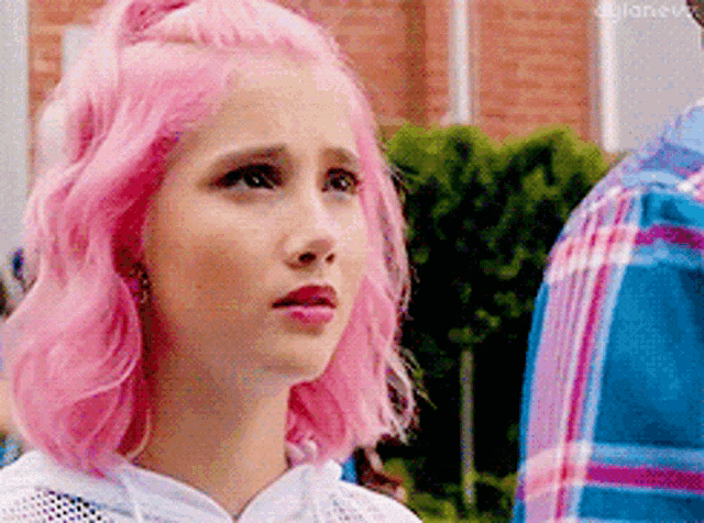 a girl with pink hair is wearing a white hoodie