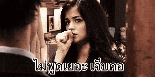a woman is covering her nose with her hand and looking at a man .