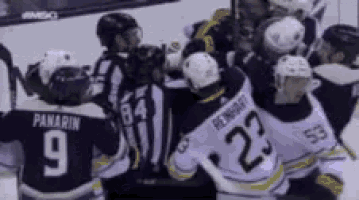 a hockey player with the number 23 on his jersey is surrounded by other players