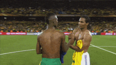 a shirtless soccer player shakes hands with another player