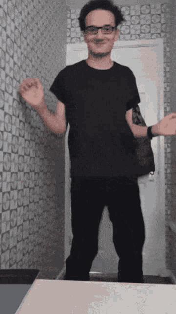 a man with glasses and a black shirt is dancing