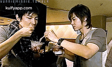 a couple of men are eating food with a tumblr.com logo in the background