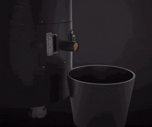 a black trash can is next to a black object