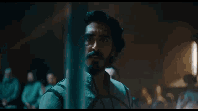 a man with long hair and a beard looks at something
