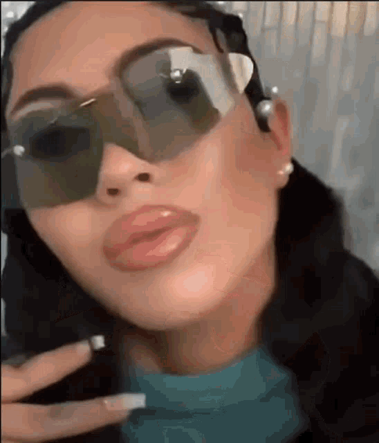 a close up of a woman wearing sunglasses and making a face