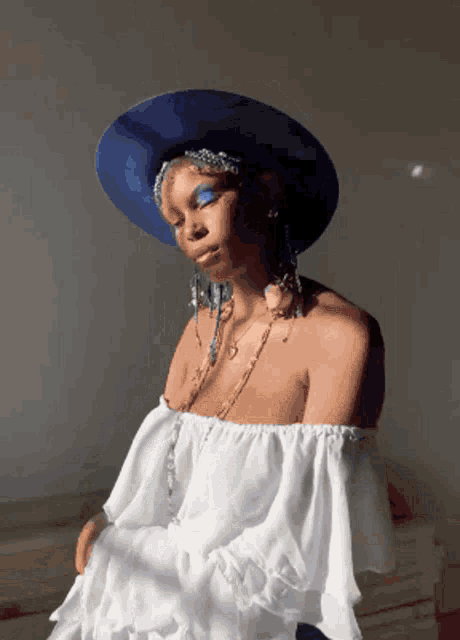 a woman wearing a blue hat and a white dress