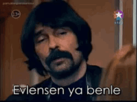 a man with a beard and mustache says evlensen ya benle in a foreign language