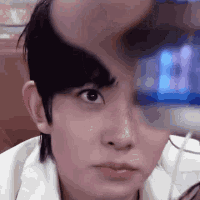 a close up of a person 's face with a blurred background of a blue light
