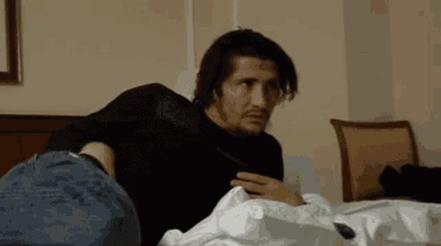 a man laying on a bed with a black shirt on
