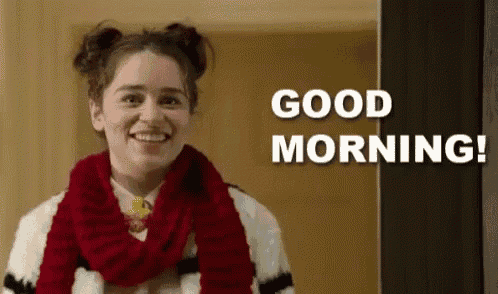 a woman wearing a scarf and buns is smiling and saying `` good morning '' .
