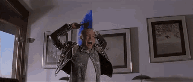a man with a blue mohawk is standing in front of a window .