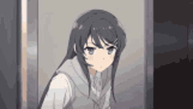 a girl with long hair is standing in front of a door looking at the camera .