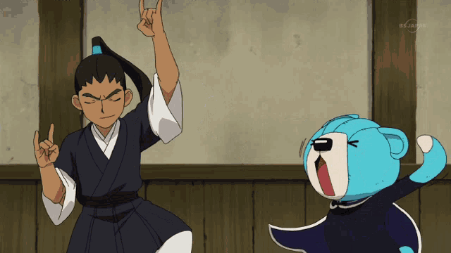 a boy in a kimono stands next to a blue teddy bear with a tv channel written on the bottom right