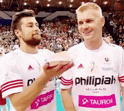 two men standing next to each other with one wearing a shirt that says philipiak