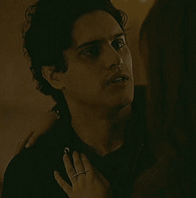 a woman is touching a man 's neck with her hand while they are kissing .