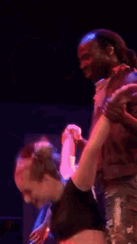 a man and woman are dancing together on a stage