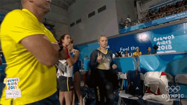a man in a yellow shirt is standing in front of a sign that says " feel the 2018 "