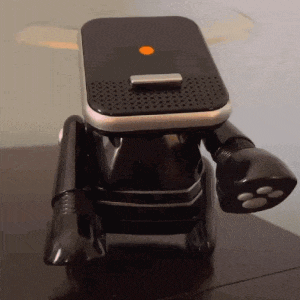 a black robot with an orange button on top