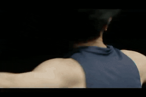 the back of a man in a blue tank top is shown in a close up .