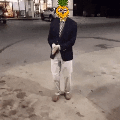 a man in a suit and tie with a pineapple on his head is walking down the street .