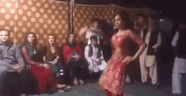 a woman is dancing on a stage in front of a crowd of people .