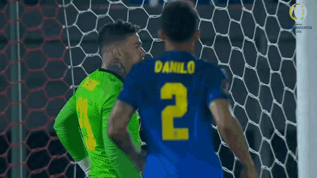 a soccer player with the number 2 on his jersey is standing next to another player
