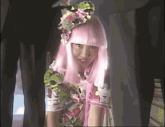 a woman wearing a pink wig and a floral dress