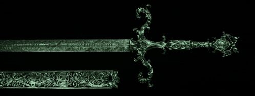a green sword with a floral design on the handle and sheath on a black background