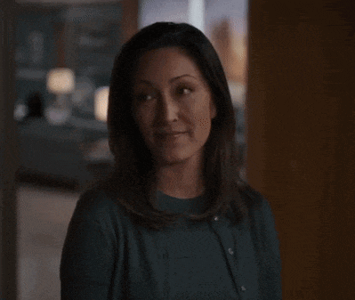 a woman in a green sweater is talking to a man in a living room .