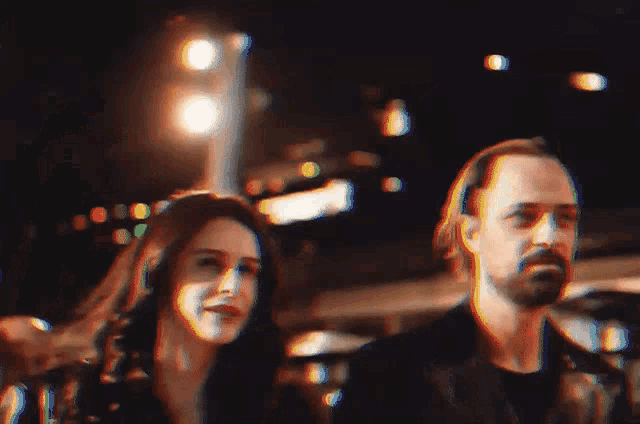 a man and a woman are standing next to each other in the dark