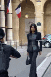 a man is taking a picture of a woman in a black suit