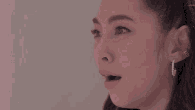 a close up of a woman 's face with her mouth open and her eyes closed .