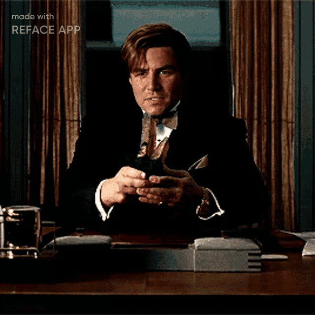 a man in a suit and bow tie is sitting at a desk with reface app on the bottom