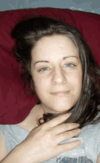 a woman laying on a couch with her hand on her hair
