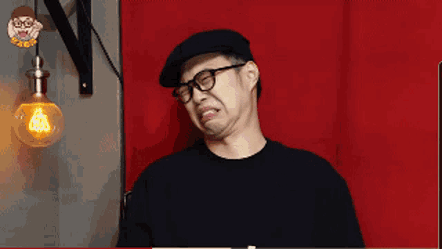 a man wearing glasses and a hat is making a face