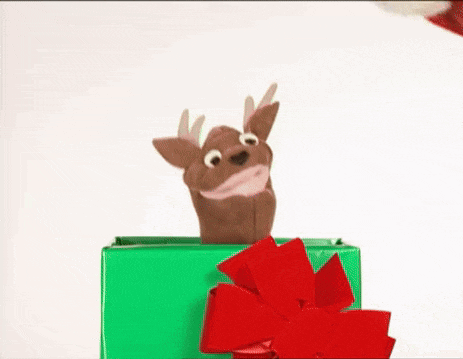 a reindeer puppet is sticking its head out of a green gift box with a red bow .