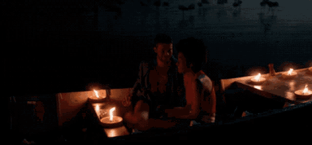 a couple sitting in a boat with candles lit up