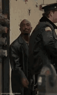 a man in a leather jacket is standing next to a police officer